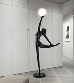 Modern ballet sculpture floor lamp with dancer figure holding illuminated globe in minimalist interior