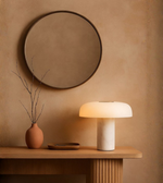 Marble dome table lamp glowing warmly on a wooden console table
