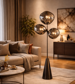 Modern smoked glass cluster floor lamp with black stand placed beside sofa in contemporary living room