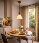 Modern marble effect cone pendant light with brass finish hanging above dining table in contemporary interior