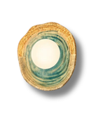 Round ceramic wall light with green and beige design on a white background