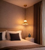 Minimal gold bedside pendant with soft diffused lighting.