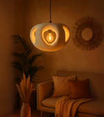 Handcrafted organic foam pendant light in white, softly glowing in modern cozy interior.