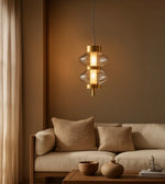 Modern gold pendant light above beige sofa in contemporary living room with neutral decor