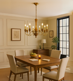 Aurelia Copperwood chandelier with candle-style bulbs in brown and copper finish, hanging elegantly above a dining setting.