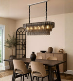 Smoked glass scallop dining chandelier with warm lighting above a modern dining table interior