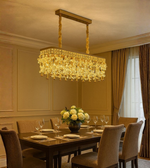 Imperial Glimmer chandelier with gold rectangular frame and crystal drops in dining space.