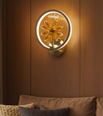 Luxury golden circular wall light with crystal flower centerpiece illuminating a modern living room interior