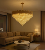 Golden Pyramid chandelier with tiered glass design illuminating a luxurious living room with warm golden tones.