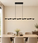 Modern black linear LED pendant chandelier with multiple warm white lights suspended above a luxury dining table.