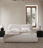 Curved upholstered bed with a plush headboard and soft fabric in a modern bedroom setting.