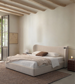 Modern minimalist bedroom with light upholstered bed, cozy bedding, and warm neutral decor