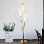 Designer floor lamp with reed-inspired brass stems and soft glow