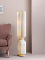 Twisted column floor lamp beside upholstered chair