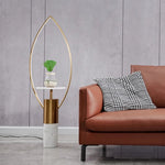 Designer leaf floor lamp with marble base next to a brown sofa