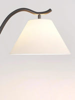 Fabric lampshade detail of modern arc floor lamp with warm lighting