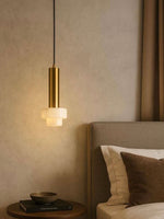 Modern pendant light fixture in a bedroom setting with neutral tones.