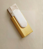 Gold marble wall sconce with warm ambient glow on neutral wall