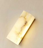Close-up of marble wall light with gold metal base and natural veining