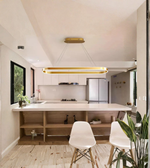 Modern kitchen with white island, chairs, and stainless steel appliances.