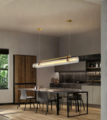 Modern kitchen with pendant lights and a dining table.