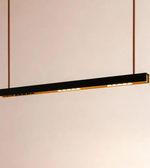 Modern pendant light with black finish and gold accents on a neutral background
