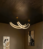 Modern chandelier hanging in a room with decorative wall art.