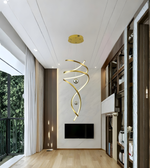 Modern interior with a gold spiral light fixture on a white wall.