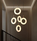 Modern chandelier with circular design hanging in a room.