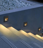 Modern outdoor fire pit with built-in lights on a concrete patio.