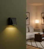 Black wall-mounted light fixture on a green wall with a living room scene in the background.