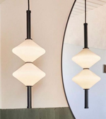 Modern pendant light fixture with geometric design in a room setting.