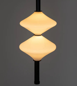 Modern pendant light with two illuminated lampshades on a dark background