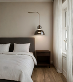 Modern bedroom with a bed, nightstand, and pendant light.