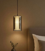 Modern pendant light fixture in a bedroom setting with a neutral color scheme.