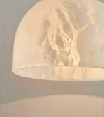 Close-up of a textured beige pendant light against a neutral background