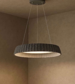 Modern pendant light hanging from the ceiling in a room with beige walls.