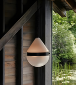 Outdoor wall light fixture on a wooden wall with natural background