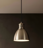 Metal pendant light hanging against a dark background