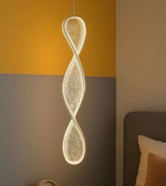 Modern pendant light fixture hanging against a wall with a gradient color scheme.