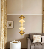 Decorative pendant light hanging in a living room with a couch and side table.