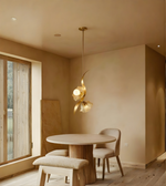 Modern dining room with a round table, chairs, and a decorative pendant light.