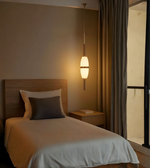 Bedroom with wooden headboard, white bedding, and pendant light.
