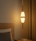 Pendant light fixture in a bedroom setting with warm lighting.