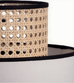 Close-up of a woven hat with a black band on a white background
