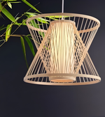 Woven pendant light with a dark background and green leaves