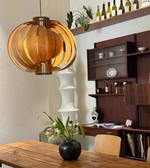 Modern interior design with wooden furniture, a pendant light, and decorative items.