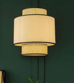 Beige pendant lamp with decorative elements against a dark green wall