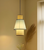 Modern pendant light fixture with a textured shade on a neutral wall.