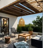 Outdoor patio with wooden pergola, chairs, and a coffee table with a scenic view.